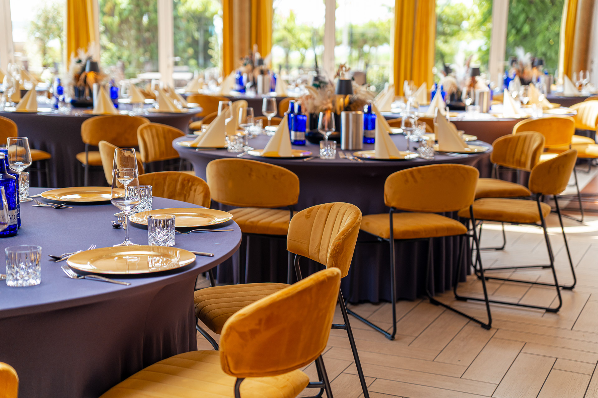 Veranstaltungsraum der Bernstein Events Location am Goitzschesee mit goldenen Stühlen und runden Tischen