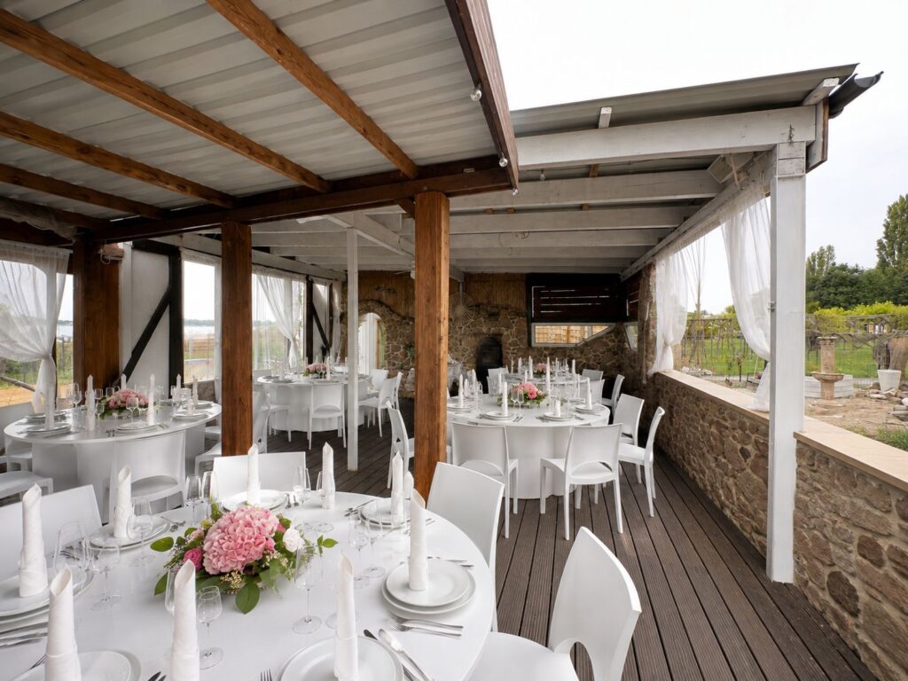 Bankett-Setup mit weißen runden Tischen und Stühlen auf dem überdeckten Holzdeck des BERNSTEIN BEACH